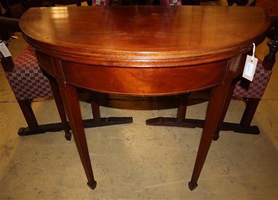 A George III inlaid mahogany demi-lune tea table with folding top